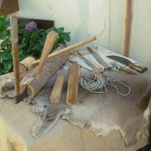 Attrezzi dell'epoca usati per fabbricare archi e frecce, e legni particolari